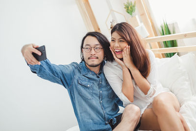 Happy young woman using mobile phone