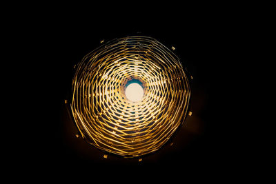 Close-up of illuminated lighting equipment against black background