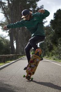 Full length of man skateboarding on road