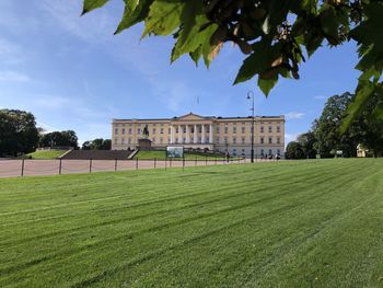 Lawn by building against sky