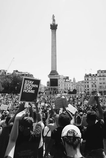 GROUP OF PEOPLE IN FRONT OF BUILDING AGAINST SKY