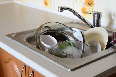 Utensils in kitchen sink at home