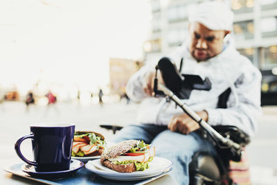 Close-up of fresh meal served for disabled man at sidewalk cafe