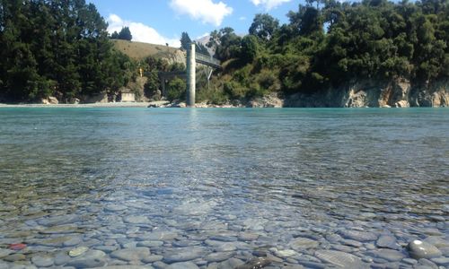 Scenic view of river against cloudy sky