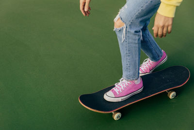 Low section of young woman standing on a skateboard 