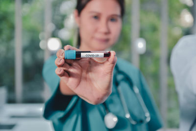 Portrait of doctor holding blood sample at hospital