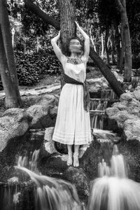 Woman standing on rock in forest