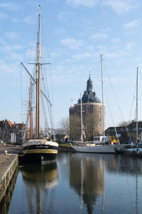 Sailboats moored at harbor