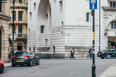 Cars on road by buildings in city