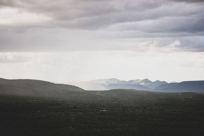 Scenic view of mountains against cloudy sky