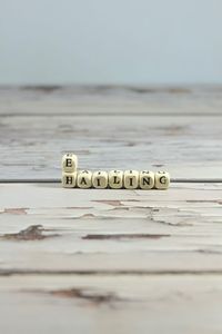 Close-up of text on table at beach against sky