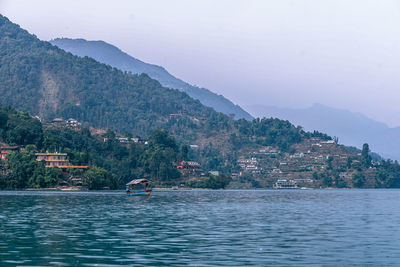 Scenic view of sea by mountains against sky