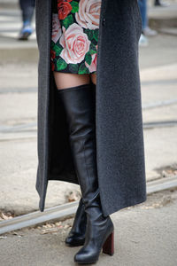 Low section of woman standing on footpath