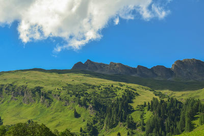 Scenic view of mountains against blue sky