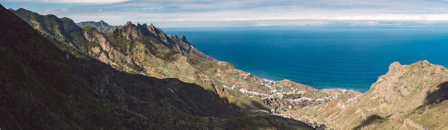 Panoramic view of sea and mountains against sky