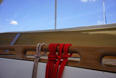 Low angle view of rope tied up against blue sky
