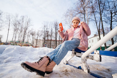 Zoomer girl uses smartphone selfie spring sunny day