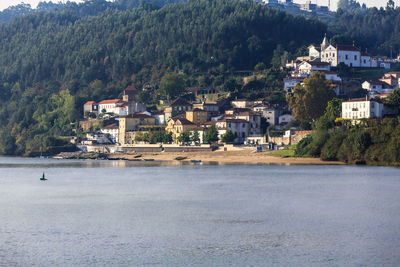 Buildings by sea against mountain