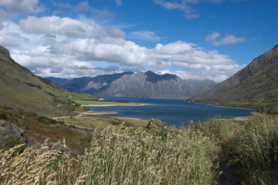 Scenic view of sea and mountains against sky