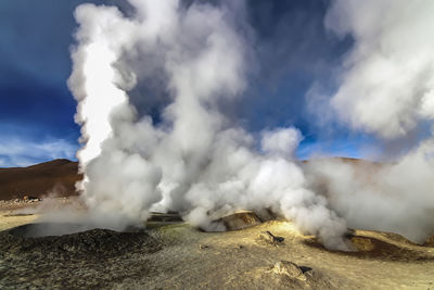 Smoke emitting from volcanic mountain against sky