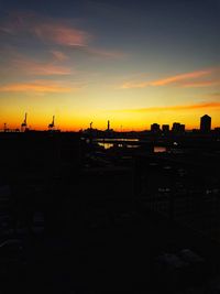 Silhouette cityscape against sky during sunset