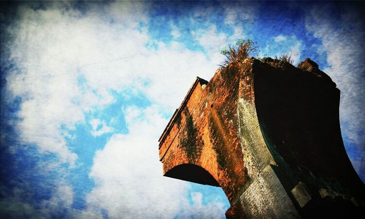 low angle view, built structure, architecture, sky, building exterior, cloud - sky, old, cloud, weathered, abandoned, damaged, wood - material, outdoors, no people, day, run-down, tree, deterioration, religion, obsolete