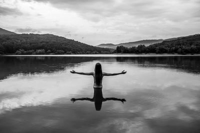 Reflection of person in lake against sky