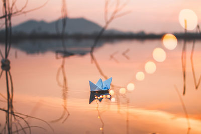 High angle view of paper boat floating in lake during sunset