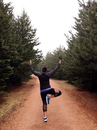 Full length of young woman against trees on field