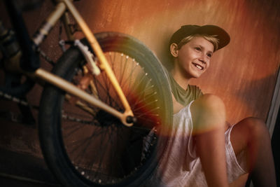 Beautiful trendy boy relaxing sitting near his bicycle young smiling man with bmx happy after riding