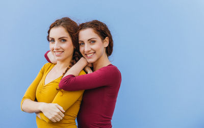 Portrait of smiling siblings against blue background