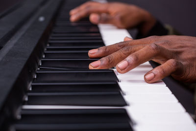 Cropped hand of woman playing piano