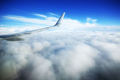 View of airplane wing and clouds in sky