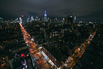 Illuminated cityscape against sky at night