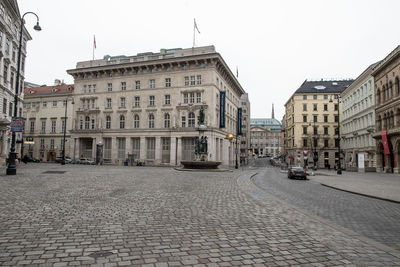 View of city street and buildings against sky