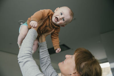 Grandmother lifting up baby at home