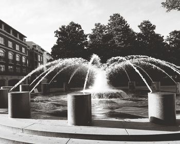 Fountain by trees against sky