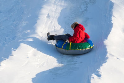 Rear view of man skiing on snow covered field