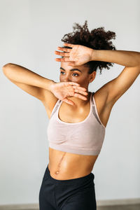 Young woman dancing against wall