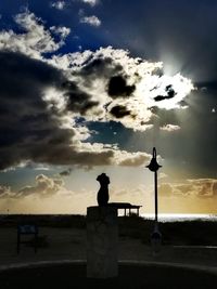 Silhouette people by sea against sky during sunset