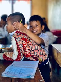 Portrait of happy boy sitting in kitchen