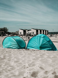 Multi colored tent on beach against sky
