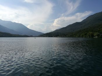 Scenic view of lake by mountains against sky