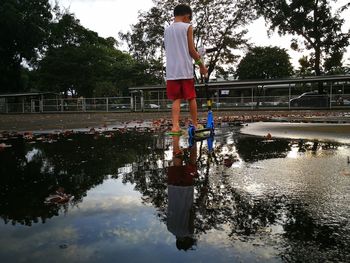 Reflection of boy standing in puddle