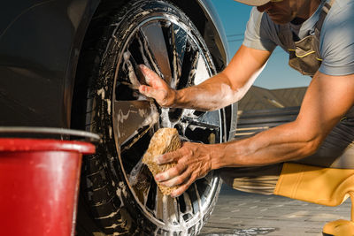 Low section of man repairing car