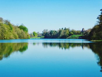 Scenic view of lake against clear blue sky