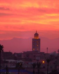 Illuminated koutoubia mosque and buildings against cloudy sky during sunrise