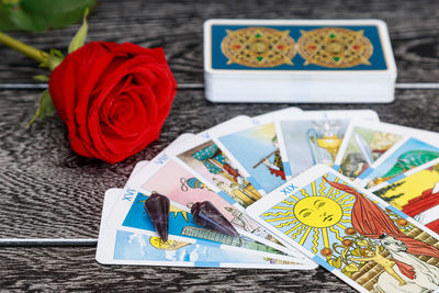 High angle view of tarot cards with rose on table