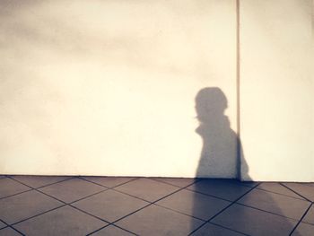 Shadow of person on tiled floor