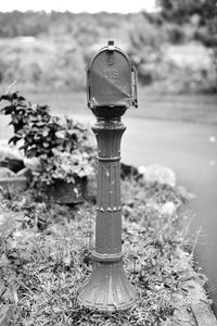 Close-up of old metal post box structure on field